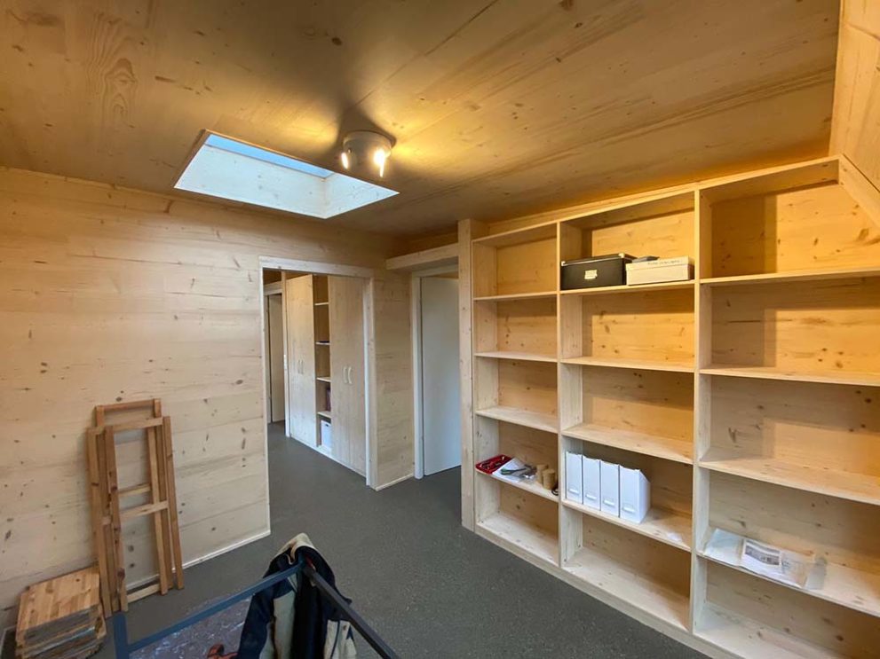 Zimmeransicht, Holzwände mit Einbauschrank und grauem Boden