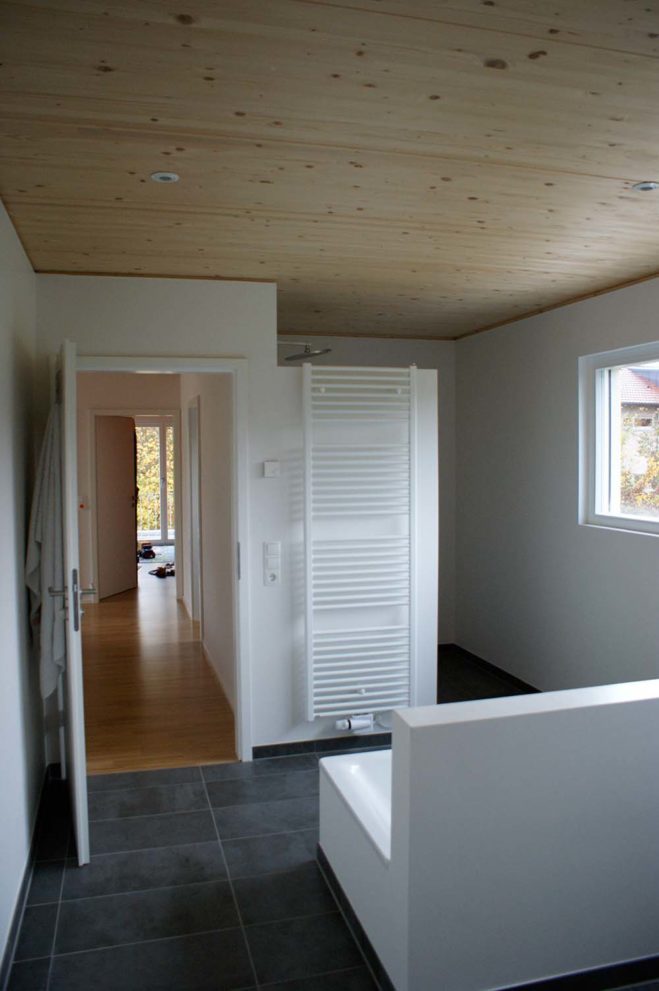 Badezimmer mit grauen Fließen und weißen Möbeln