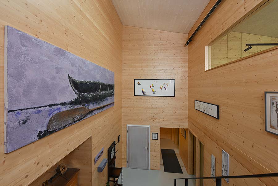 Flur eines Holzhauses mit unterschiedlichen Gemälden an den Wänden