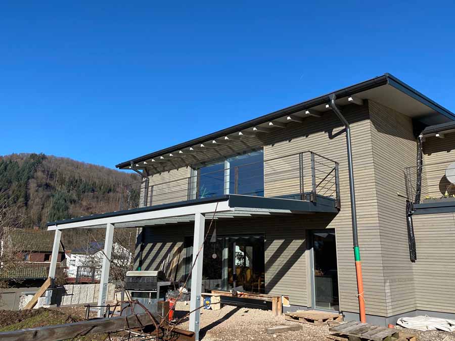 Überdachte Terrasse eines Holzhauses