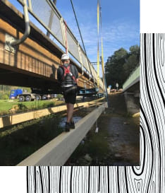 Arbeiter befördern eine neugebaute Holzbrücke an ihren neuen Standort.