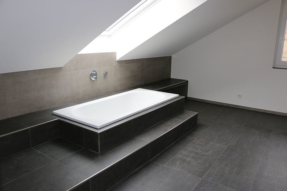 Badezimmer mit großer Badewanne unter einem Dachfenster